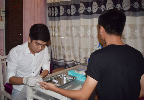 Nhân viên tiếp cận cộng đồng đang thực hiện xét nghiệm lấy máu đầu ngón tay bằng test “đôi” HIV và giang mai.