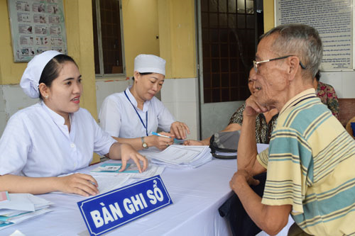 Cán bộ y tế Trạm Y tế phường Phước Thới, quận Ô Môn lập sổ quản lý sức khỏe cho người dân theo nguyên lý YHGĐ.